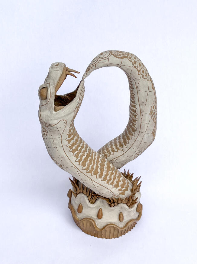 Earth tone ceramic snake eating its own tail sculpture with sgraffito details. Ouroboros